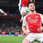 Arsenal venceu o Real Madrid por 3 a 0 na Champions League, com dois gols de falta de Declan Rice e um de Mikel Merino. Mbappé se destacou no Real, mas brasileiros falharam. O jogo da volta será no Bernabéu, com o Arsenal em vantagem.